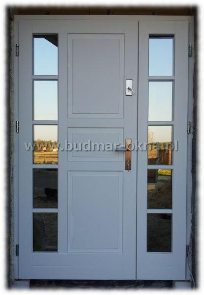 Białe drzwi zewnętrzne z czterema szybkami po bokach, widoczny zamek i klamka, model DZR-44.