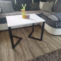Biały stolik kawowy z czarnymi, spawane nogami w stylu industrialnym, dekoracje wielkanocne na blacie. Wykonanie Elbląg.