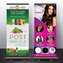 Dwa roll-upy reklamowe: jeden promujący post Daniela z warzywami i owocami, drugi studio urody Queen z ofertą fryzjera, make-upu, pielęgnacji włosów i stylizacji paznokci, z logo i danymi...