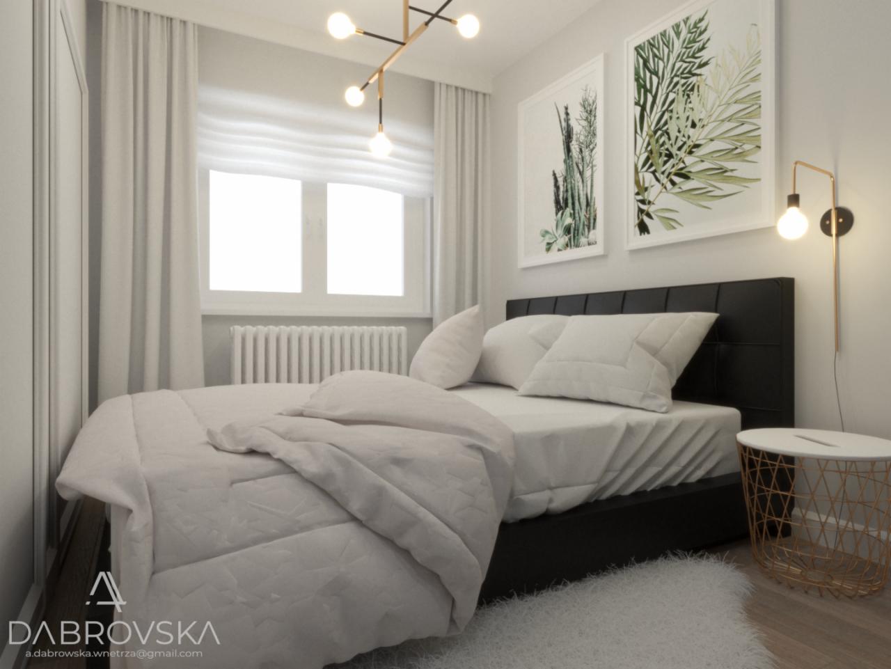 Jasna sypialnia z czarnym łóżkiem, białymi tekstyliami, minimalistycznym oświetleniem i grafikami botanicznymi na ścianie, uzupełniona białym dywanem i złotym stolikiem nocnym.