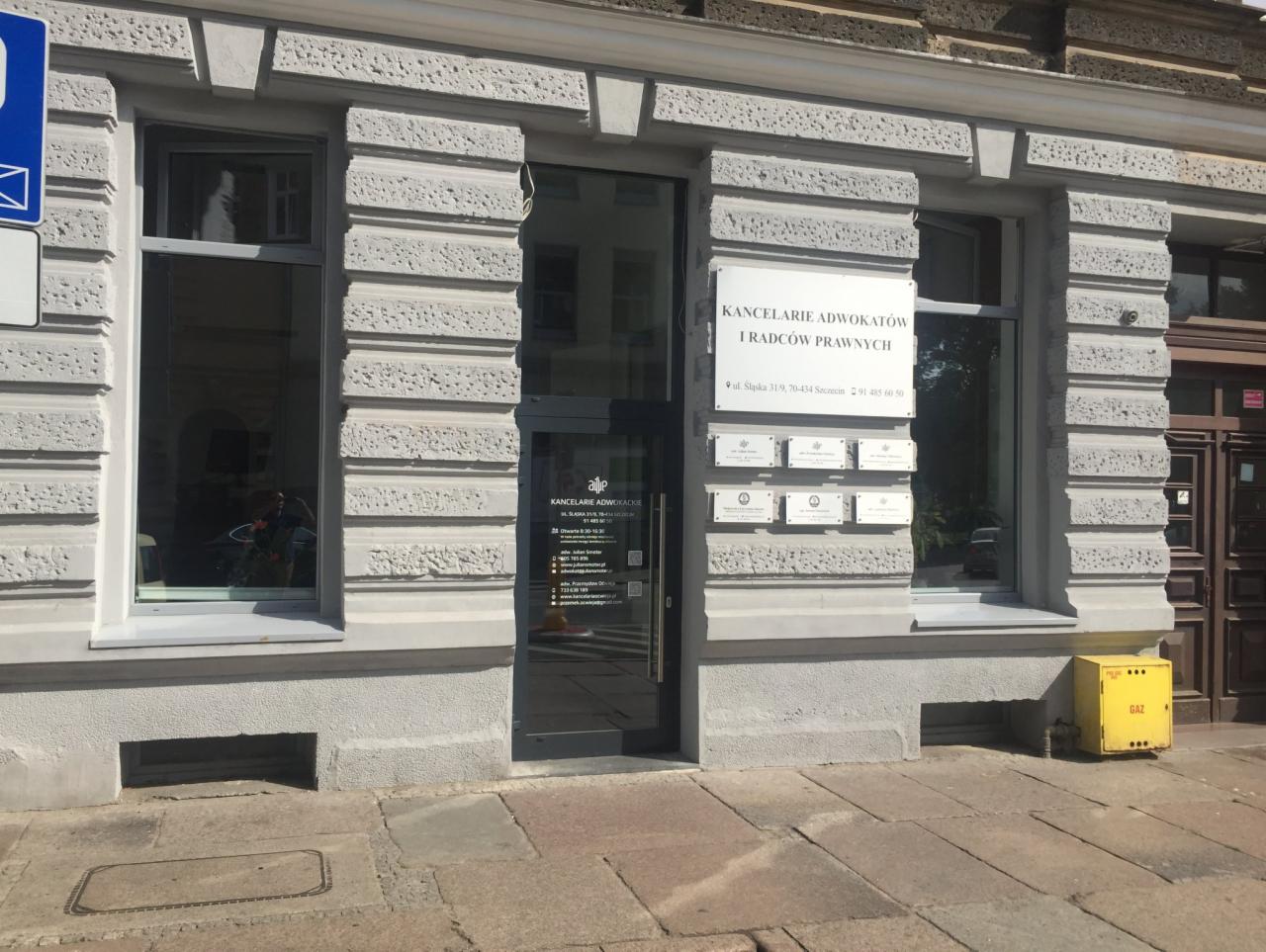 Fasada kamienicy z szyldem 'Kancelarie Adwokatów i Radców Prawnych' przy ulicy Śląskiej w Szczecinie, z widocznymi tabliczkami z nazwiskami prawników i żółtą skrzynką gazową obok.