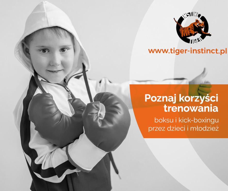 Uśmiechnięty chłopiec w bluzie z kapturem i rękawicach bokserskich, prezentacja korzyści z treningu boksu i kickboxingu dla dzieci i młodzieży, logo Tiger Instinct w tle.