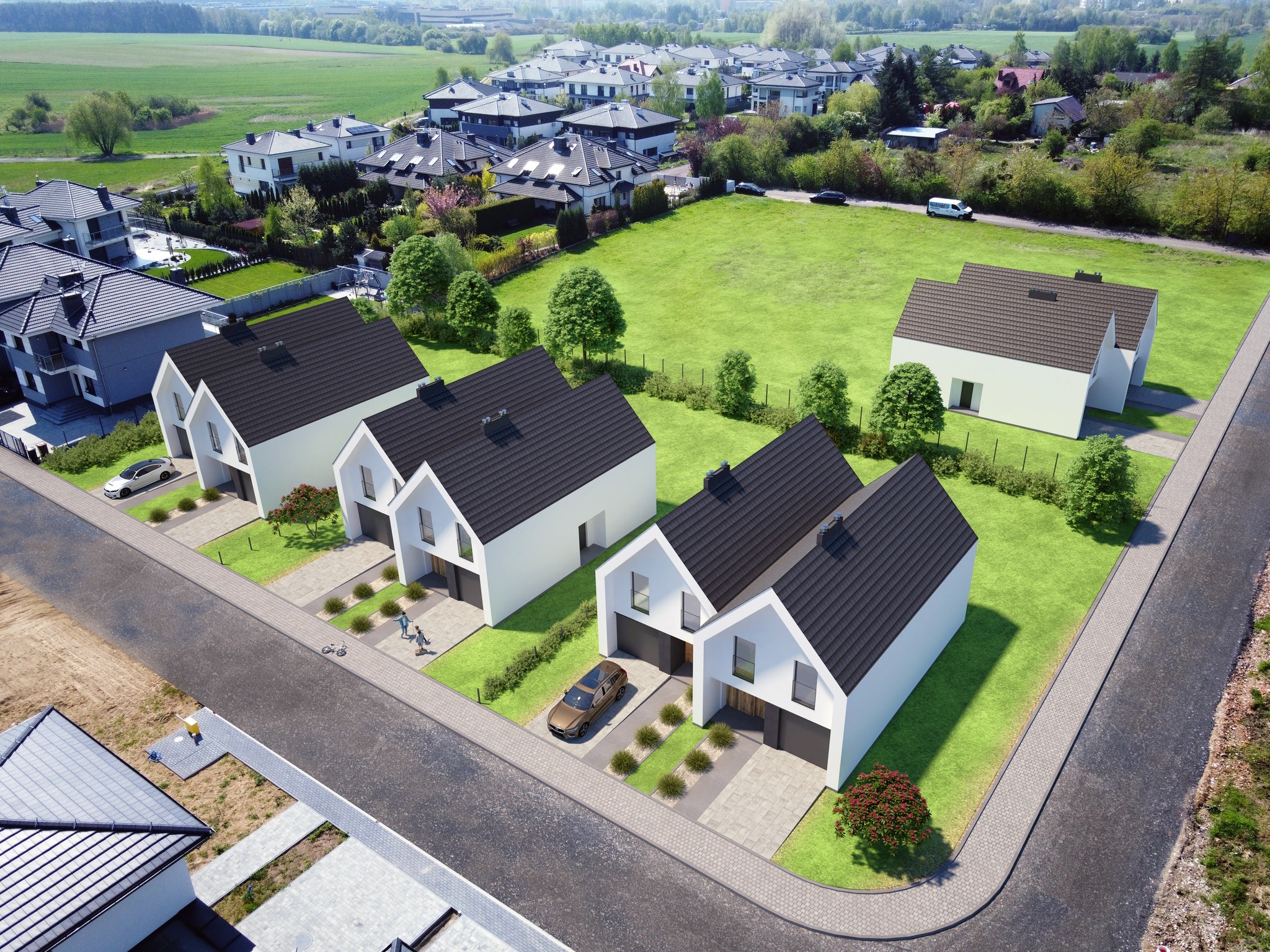 Osiedle domów jednorodzinnych w nowoczesnym stylu z ciemnymi dachami, widok z lotu ptaka, z zadbanymi trawnikami i kostką brukową przed garażami.