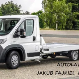 Biała laweta marki Fiat Ducato z platformą załadunkową ISOLI, zaparkowana na asfalcie z zielonymi drzewami w tle, z widocznym numerem telefonu kontaktowego.