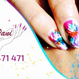 Zbliżenie na dłoń z pomalowanymi paznokciami w abstrakcyjne wzory w odcieniach różu, bieli, turkusu i fioletu, z widocznym logo salonu i numerem telefonu na białym tle z kolorowymi kropkami.