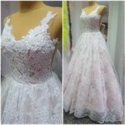 Koronkowa suknia ślubna z delikatnym różowym podkładem, prezentowana na manekinie, z detalami koronki widocznymi na zbliżeniu.