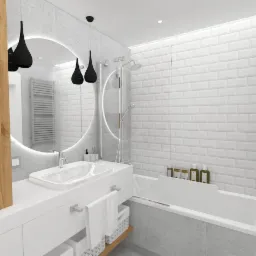 Nowoczesna łazienka z owalnym lustrem podświetlanym LED, czarnymi lampami wiszącymi, białą umywalką nablatową, wanną obudowaną szarymi płytkami i ścianą z białych płytek typu metro.