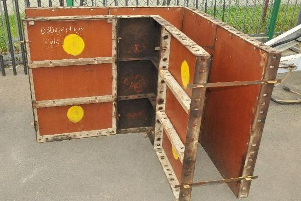 Zestaw brązowych szalunków stalowych z żółtymi okręgami, ustawionych pod kątem prostym na szarym podłożu.