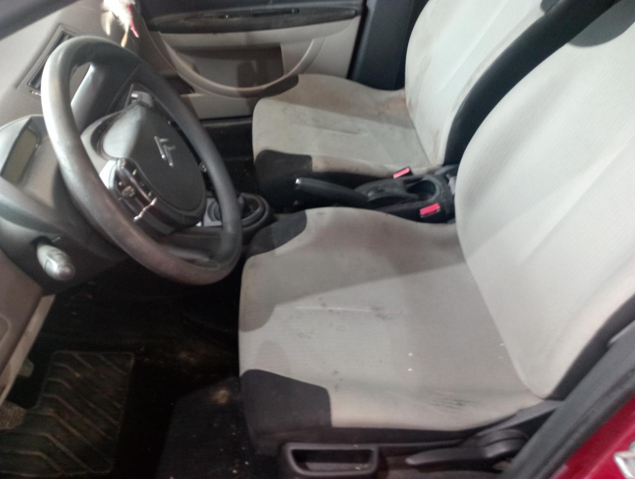 Wnętrze samochodu Citroen z widocznymi, zabrudzonymi jasnymi fotelami, kierownicą z logo i dywanikami. Wnętrze wymaga odświeżenia.