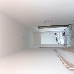 Firma Remontowo Budowlana Tomasz Piechota - Wnętrze w trakcie remontu: widoczne płyty karton gips, otwory w ścianie pod instalacje elektryczne oraz zabezpieczona folią podłoga.