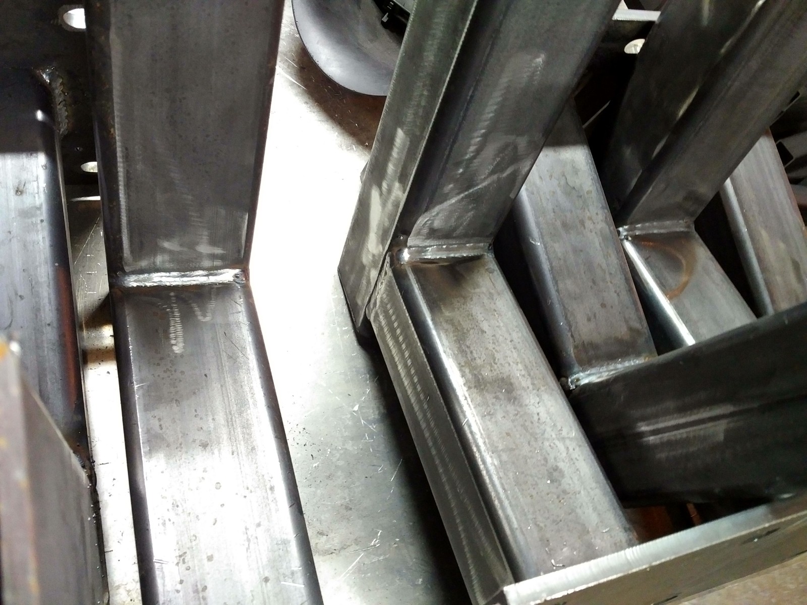 Surowe, spawane profile stalowe, prawdopodobnie elementy konstrukcyjne bramy wjazdowej, widoczne ślady obróbki i spawania.