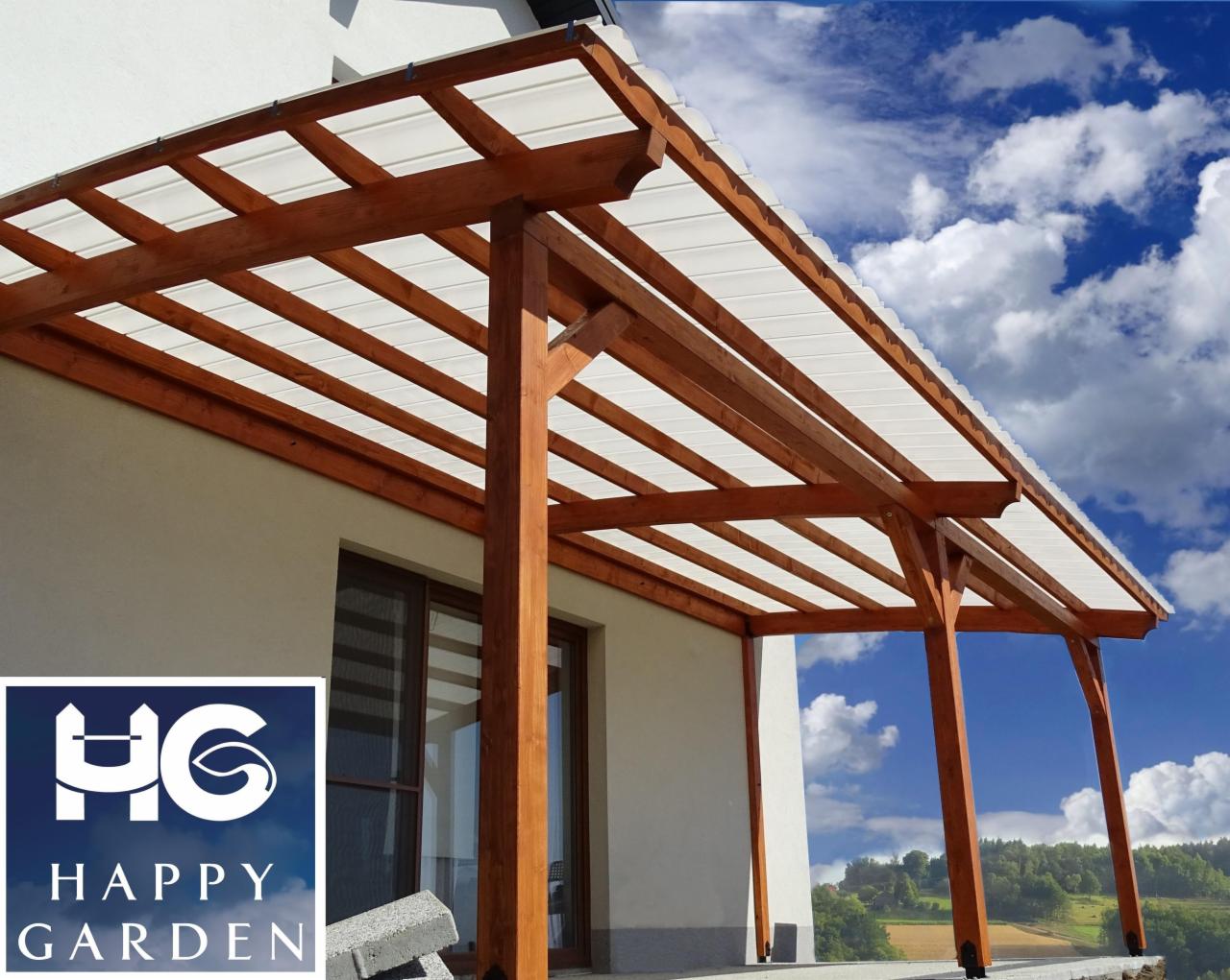 Drewniana pergola z białym zadaszeniem przylegająca do jasnego budynku, widoczne niebieskie niebo w tle, logo Happy Garden w lewym dolnym rogu.
