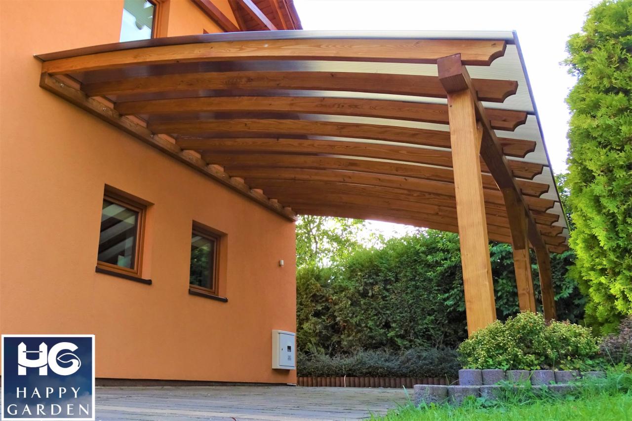 Drewniana konstrukcja z przezroczystym zadaszeniem przylegająca do pomarańczowej ściany domu, widoczne dwa okna i logo firmy w rogu.