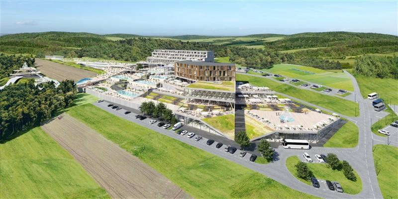 Wizualizacja z lotu ptaka nowoczesnego kompleksu hotelowego z basenami termalnymi, parkingiem i otaczającym krajobrazem.