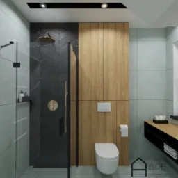 Wizualizacja nowoczesnej łazienki z kabiną prysznicową typu walk-in, toaletą podwieszaną, szafką z drewnianymi frontami i akcentami w kolorze złota, podkreślona przez czarne elementy wykończeniowe...