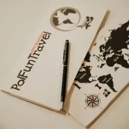 Otwarty folder z mapą świata i logo PolFunTravel, czarny długopis Steigenberger Aldau Resort leży na wierzchu.