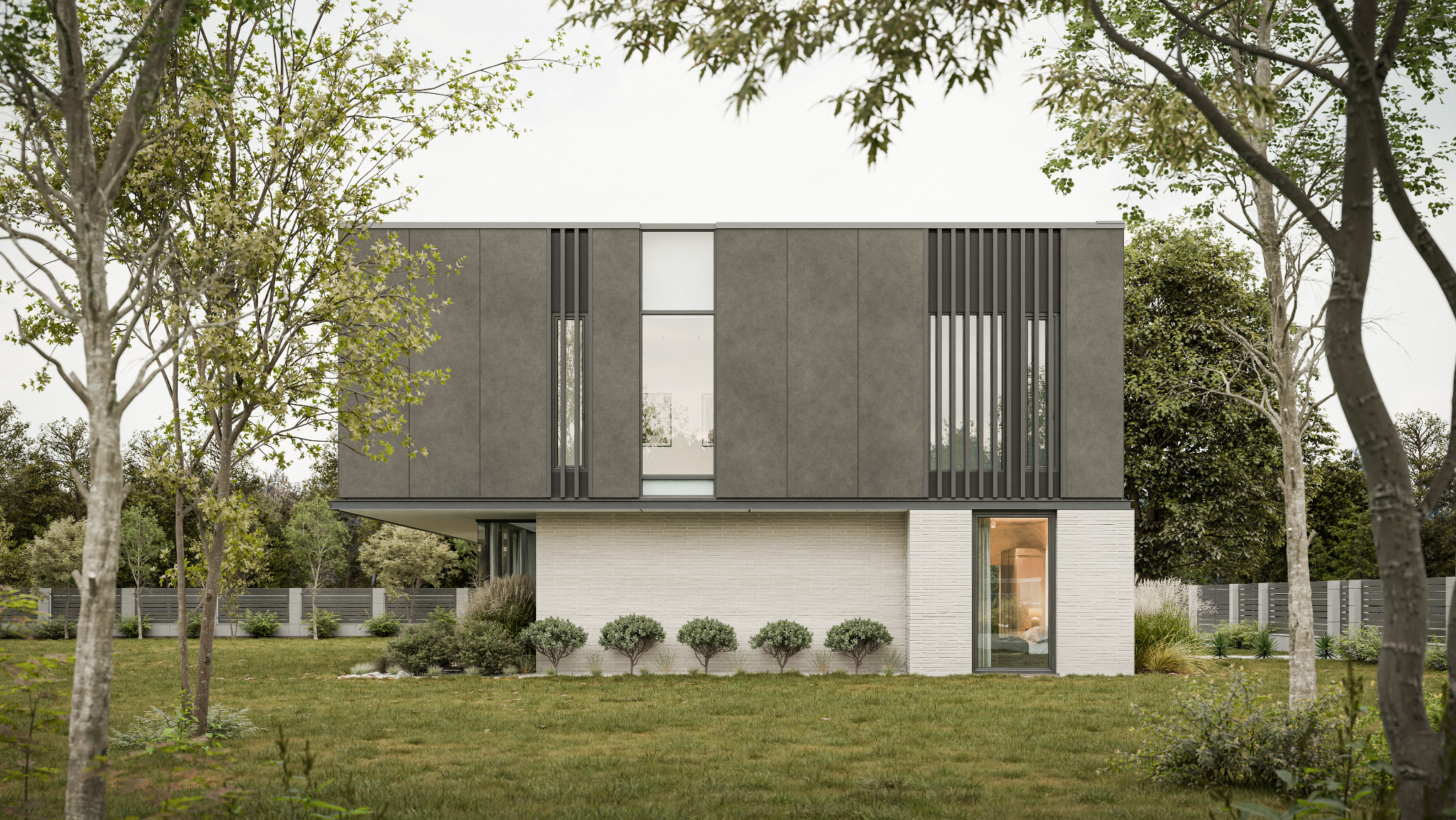 Dwukondygnacyjny dom z szarą elewacją i białym, ceglanym dołem, otoczony zielenią. Minimalistyczny design z dużymi oknami i pionowymi panelami. Widok z poziomu trawnika.