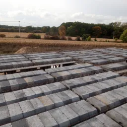 Widok z góry na strop Teriva z szarych pustaków betonowych ułożonych na stalowych belkach, w tle pole kukurydzy i drzewa.