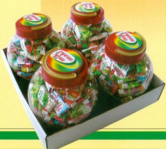 Cztery słoiki z drażetkami owocowymi MIK MAKI w tekturowym pudełku, widoczne etykiety i kolorowe cukierki.