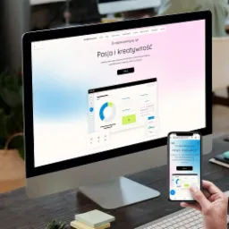 Ekran komputera stacjonarnego wyświetlający stronę internetową zinnejperspektywy.net z nagłówkiem 'Pasja i kreatywność', obok leżą karteczki samoprzylepne, a w dłoni trzymany jest smartfon z tą...