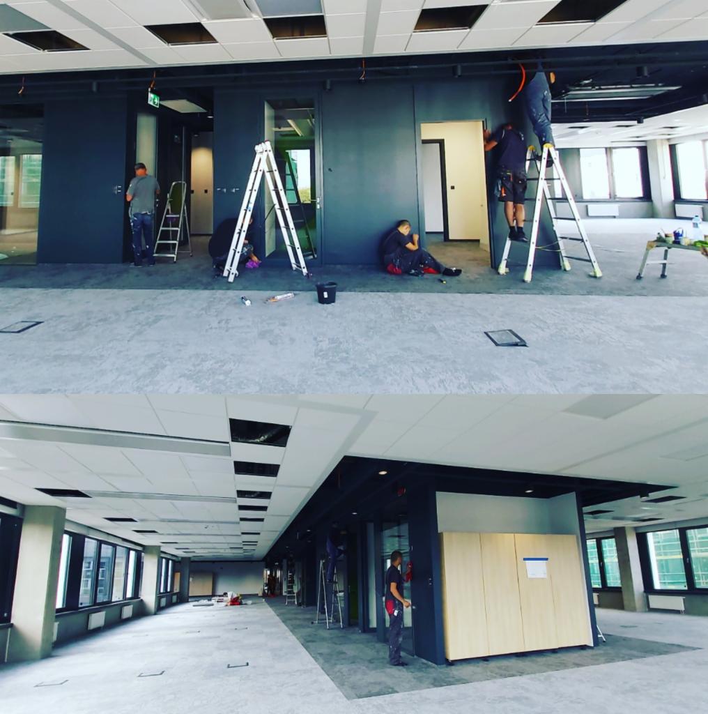 Prace wykończeniowe w biurze: montaż ścianek działowych i prace malarskie, widoczne drabiny, narzędzia i ekipa remontowa w trakcie pracy.