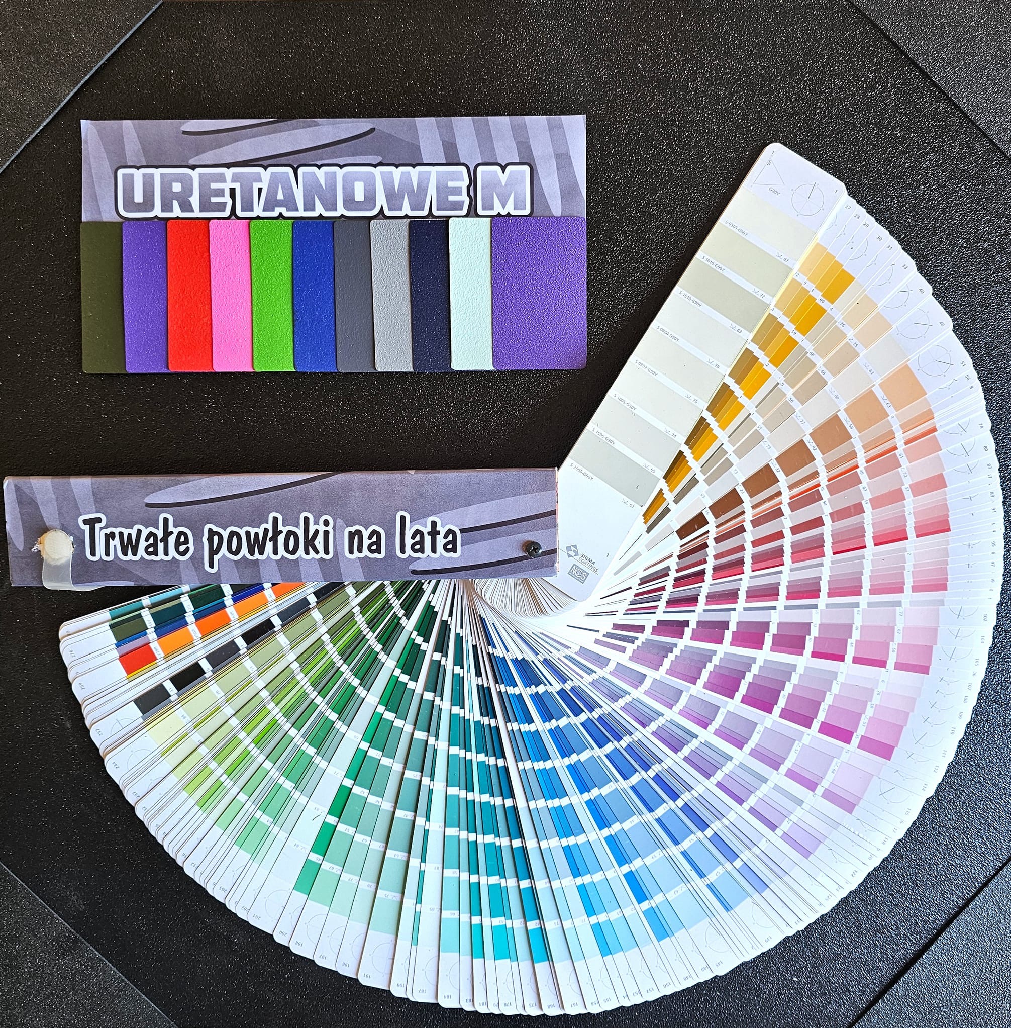 Paleta kolorów 'Uretanowe M' z próbkami trwałych powłok, prezentująca szeroki wachlarz odcieni na czarnym tle. Kolornik wachlarzowy z numeracją.