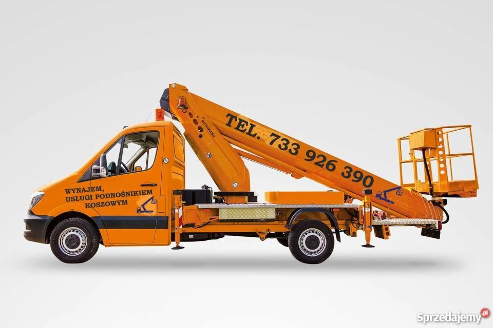 Pomarańczowy samochód dostawczy z podnośnikiem koszowym, na ramieniu podnośnika widoczny numer telefonu kontaktowego.