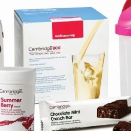 Zestaw produktów Cambridge Weight Plan: napój czekoladowy, proszek o smaku letnich jagód, batonik czekoladowo-miętowy, koktajl truskawkowy w kartonie oraz shaker z różową nakrętką.