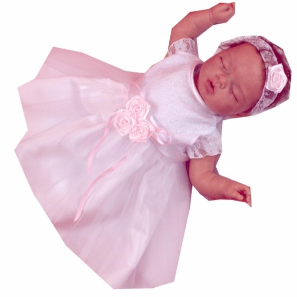 Lalka w białej sukience z koronkową górą i różowymi aplikacjami w kształcie różyczek na gorsecie i opasce na głowie.