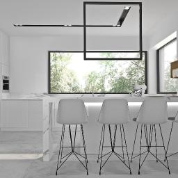 Sylwia Bartkiewicz Pracownia Architektury Wnętrz - Nowoczesna biała kuchnia z marmurowym blatem, wyspą i czterema szarymi hokerami na czarnych nogach, oświetlona geometryczną lampą sufitową i podświetleniem półek, z widokiem na zieleń za oknem.