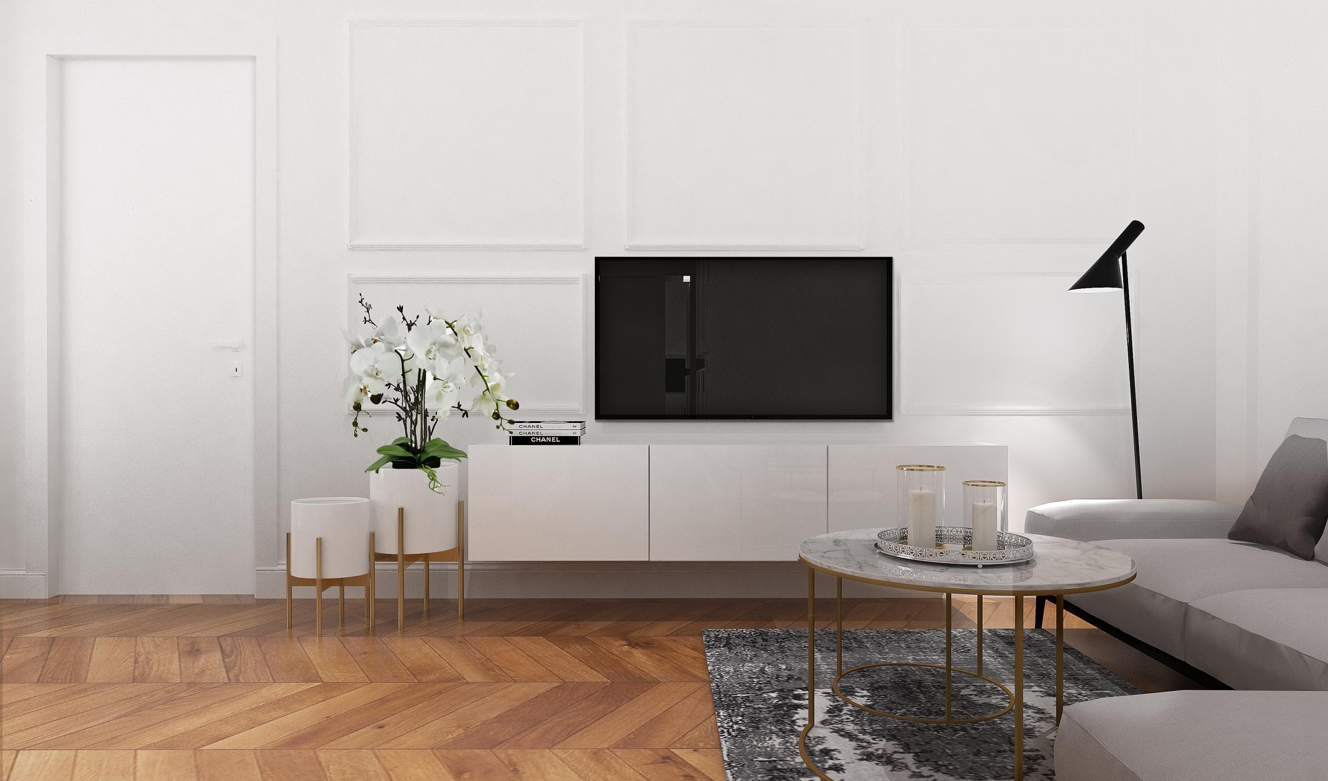Jasne wnętrze salonu z parkietem w jodełkę, białą ścianą z dekoracyjnymi panelami, telewizorem, niską szafką RTV, marmurowym stolikiem kawowym na złotych nóżkach, białą sofą i czarną lampą podłogową.