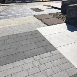 Ekspozycja różnorodnych wzorów i kolorów nawierzchni z kostki brukowej oraz płyt betonowych na terenie składu budowlanego w Spytkowicach, prezentująca aranżacje z wykorzystaniem kamieni ozdobnych.