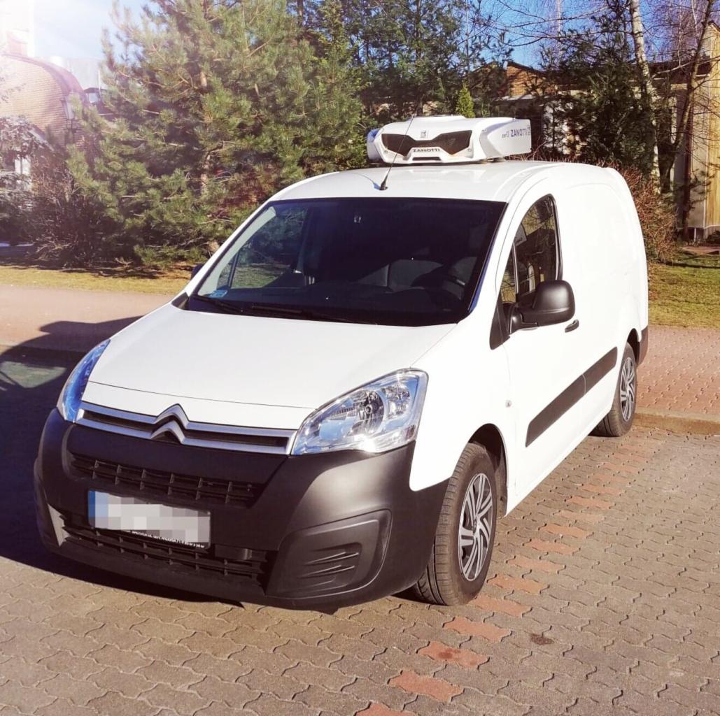 Biały samochód dostawczy marki Citroen z agregatem chłodniczym Zanotti na dachu, zaparkowany na kostce brukowej w słoneczny dzień.