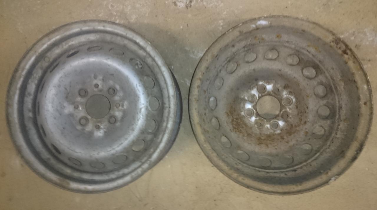 Dwie stalowe felgi samochodowe, jedna po prawej stronie z widocznymi śladami rdzy i starej farby, druga po lewej stronie po czyszczeniu, przygotowana do dalszej obróbki.
