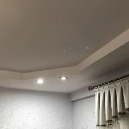 Wykończony sufit podwieszany z oświetleniem punktowym i dekoracyjnym gzymsem, ściana z fakturą, zasłony z kryształkami