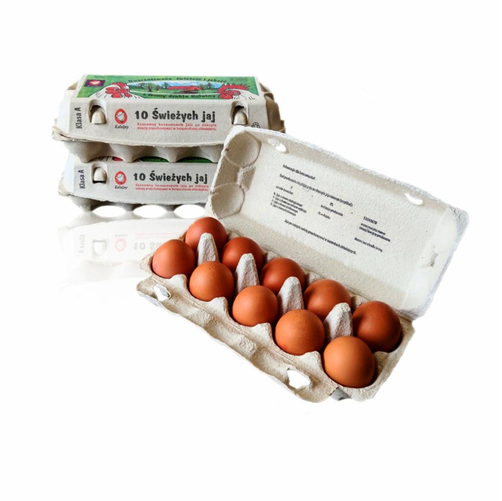Brązowe kurze jaja w otwartym kartonowym opakowaniu, obok ułożone dwa zamknięte kartony z napisem '10 Świeżych jaj' i grafiką kury. Widoczny tekst informacyjny na opakowaniach.