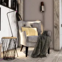 Szary fotel z poduszką i pledem, obok stolik z lampą, kosz z dokumentami i wazon z rośliną, minimalistyczny wystrój wnętrza z geometrycznymi obrazami na ścianie.