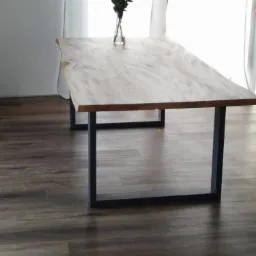 Stół z blatem z jasnego drewna o nieregularnych krawędziach i czarnych, metalowych nogach w kształcie prostokątów, na podłodze z paneli imitujących ciemne drewno, z wazonem z kwiatami na blacie,...