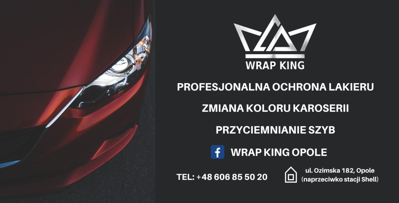 Czerwony samochód z bliska, obok logo firmy Wrap King oferującej profesjonalną ochronę lakieru, zmianę koloru karoserii i przyciemnianie szyb. Widoczny fragment reflektora i karoserii.