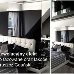 Sypialnia z łóżkiem z pikowanym zagłówkiem, czarno-białą pościelą i dekoracyjnym panelem ściennym z lustra fazowanego i lakobelu, odbijającym okno z firanką.