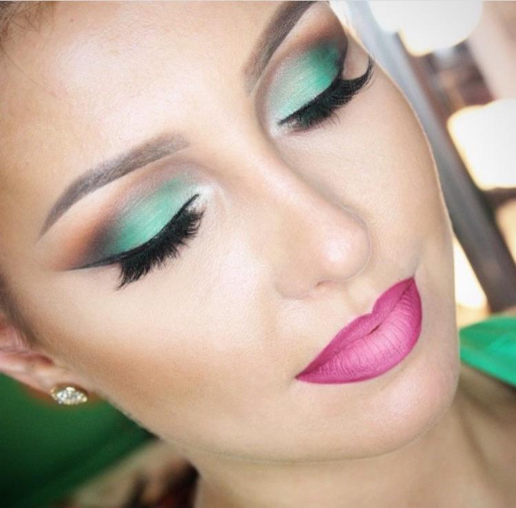 Portret kobiety z zamkniętymi oczami prezentującej profesjonalny, artystyczny make-up: intensywnie zielone cienie z brązowym akcentem, długie sztuczne rzęsy i matowa, różowa szminka ombre.