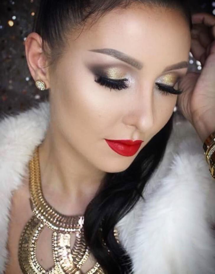 Portret kobiety z wyrazistym, wieczorowym w złoto-brązowych tonacjach, czerwone usta, futrzane okrycie i złota biżuteria.