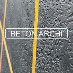 Rewolucja Wnętrz i Elewacji. Daniel Gardocki - Czarna ściana o szorstkiej fakturze betonu architektonicznego, z geometrycznym wzorem z cienkich, złotych linii, zbliżenie na detal.