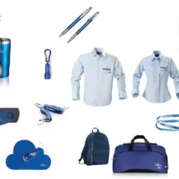 Zestaw gadżetów reklamowych w odcieniach niebieskiego i bieli, w tym koszule, torby, długopisy, pendrive, myszka, latarka, scyzoryk, kubek termiczny, smycz i podkładka pod mysz z logo firmy...