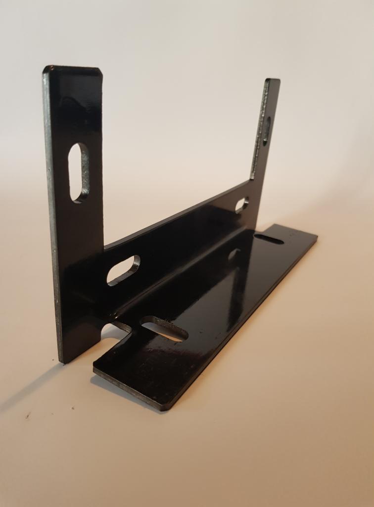 Czarny, metalowy wspornik kątowy z otworami, ustawiony pod kątem na jasnym tle, widoczne refleksy światła na błyszczącej powierzchni.