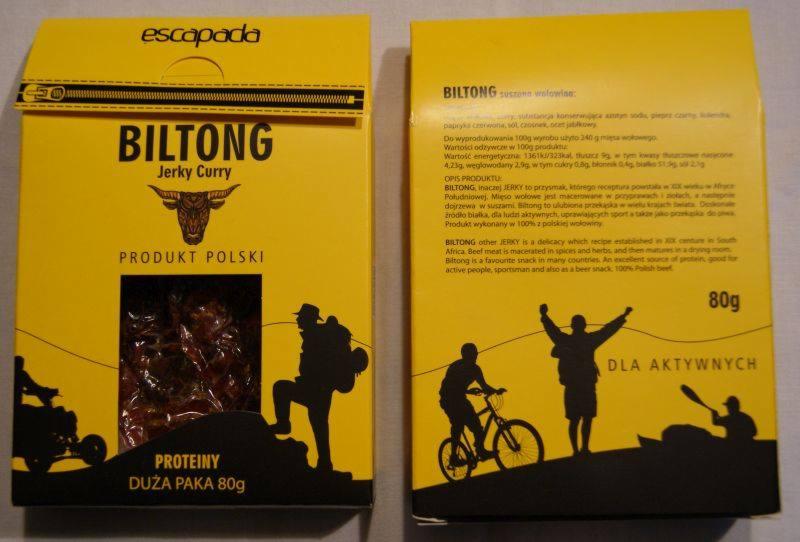 Żółte opakowanie Biltong Jerky Curry z wołowiną, z grafiką sylwetek osób uprawiających sport i turystykę, informacją o wysokiej zawartości białka i wadze 80g.