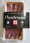 Plastry pastrami w przezroczystym opakowaniu na beżowej tacce, z widoczną etykietą z nazwą produktu i logotypem producenta.
