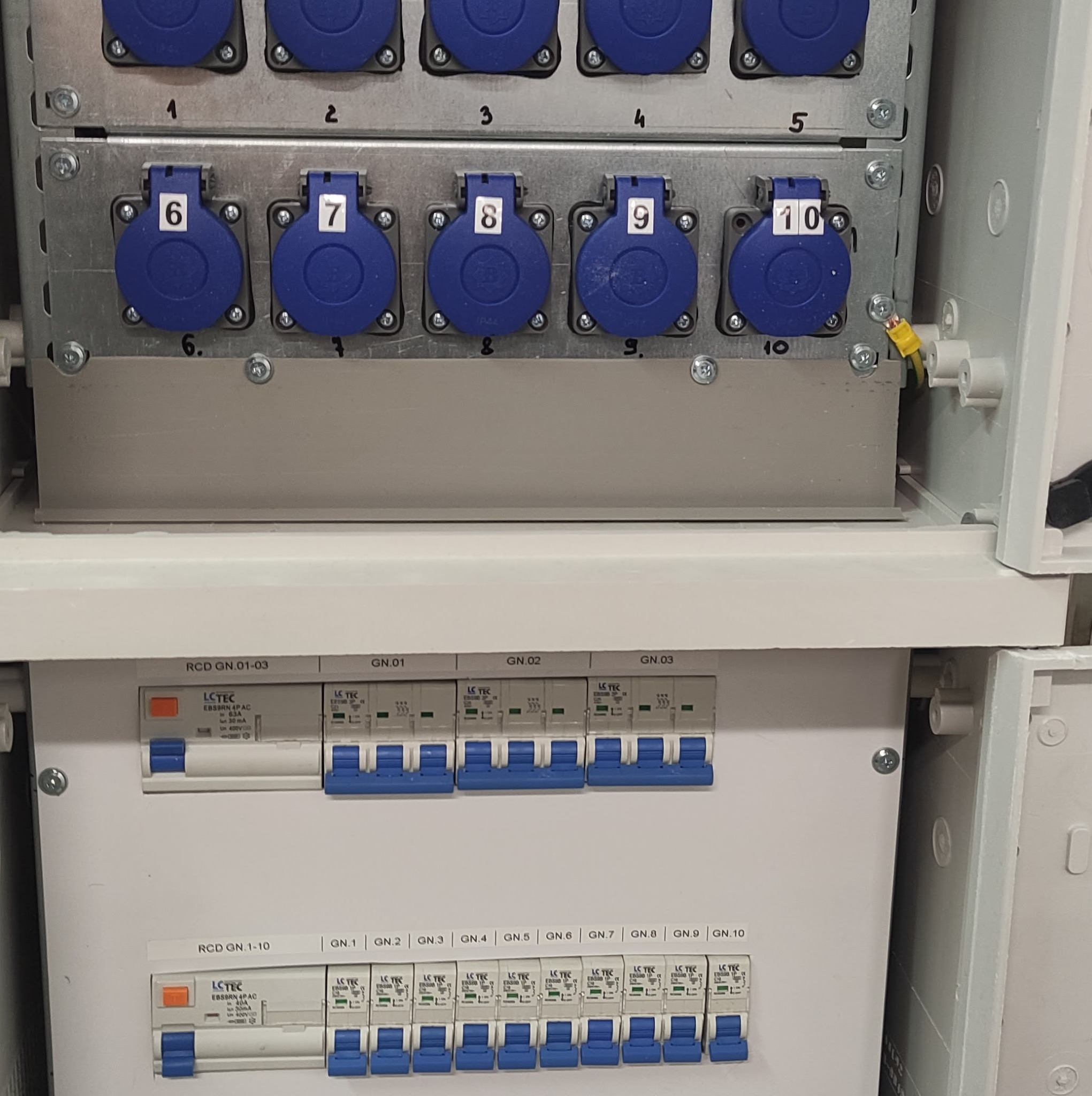 Rozdzielnica elektryczna z gniazdami przemysłowymi oznaczonymi numerami 1-10 oraz zabezpieczeniami różnicowoprądowymi i nadprądowymi firmy LCTEC, widoczne okablowanie.