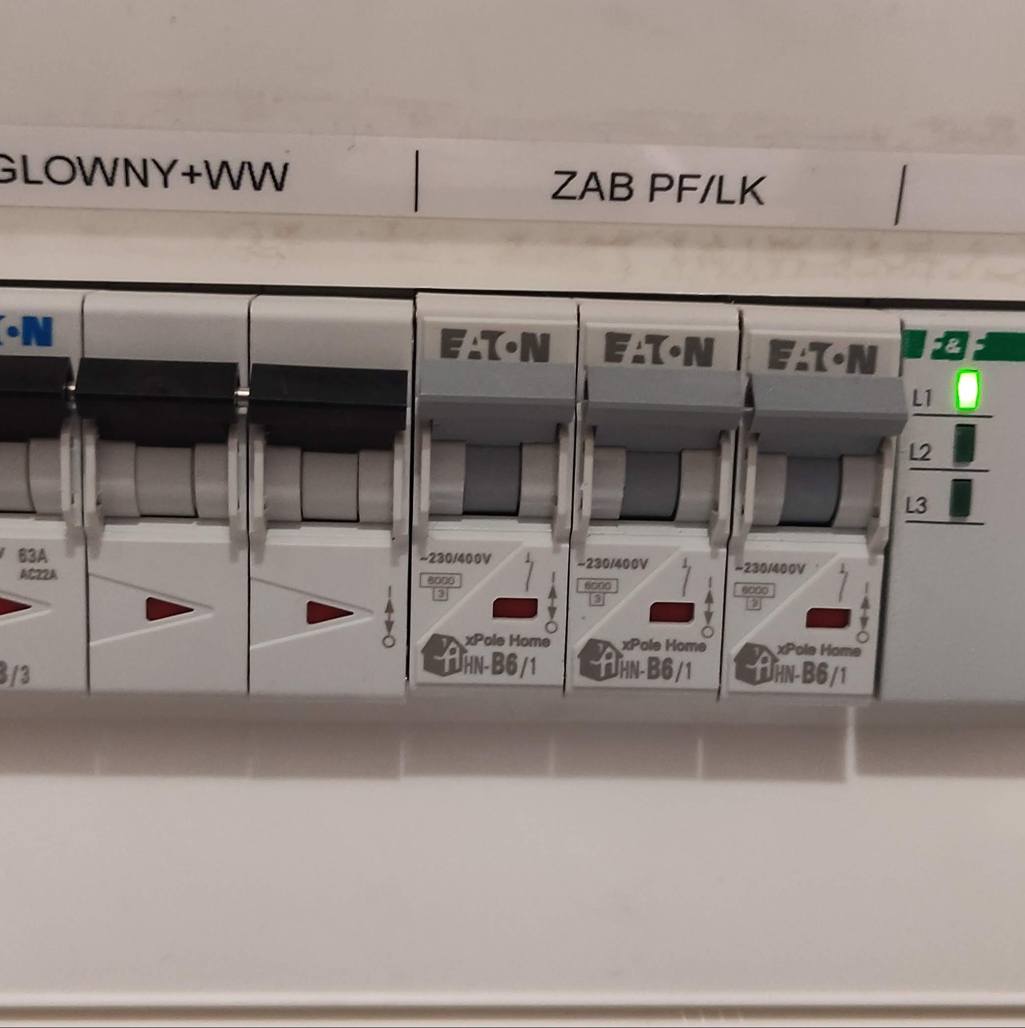 Szczegółowe ujęcie tablicy rozdzielczej Eaton xPole Home z wyłącznikami nadprądowymi, z widocznymi oznaczeniami i diodami sygnalizacyjnymi L1, L2, L3, wskazującymi na stan obwodu.
