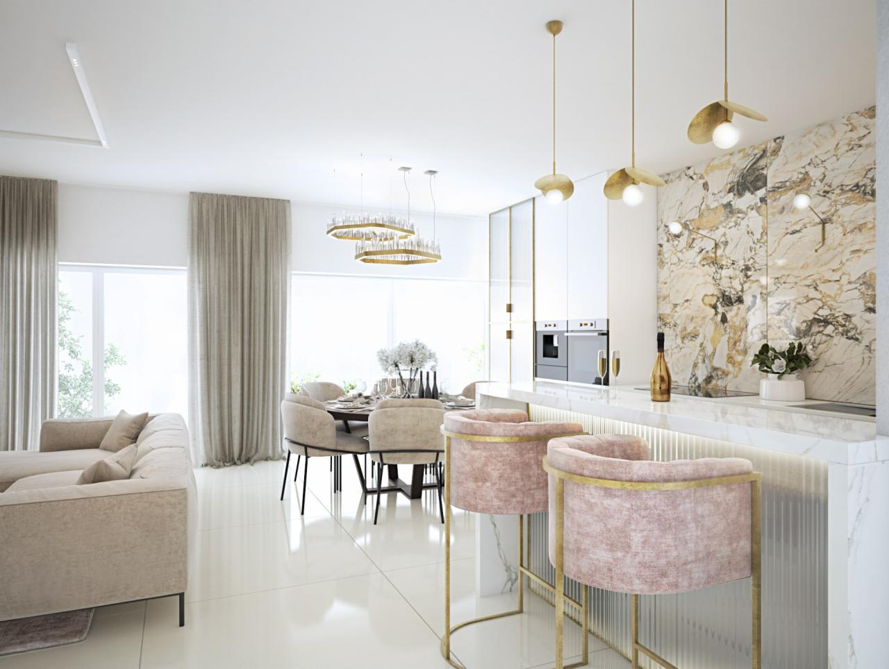 Jasne, przestronne wnętrze z marmurową ścianą, złotymi lampami wiszącymi, różowymi krzesłami barowymi z metalowymi nogami, beżową sofą i okrągłym stołem jadalnym z beżowymi krzesłami.